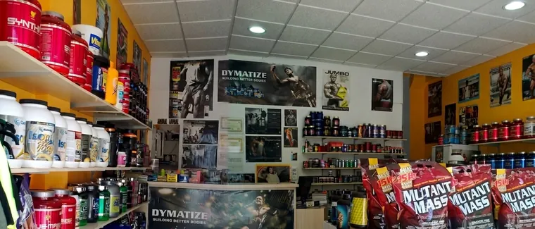 Primer local de Protein Center, con estanterías de botes y carteles en la pared